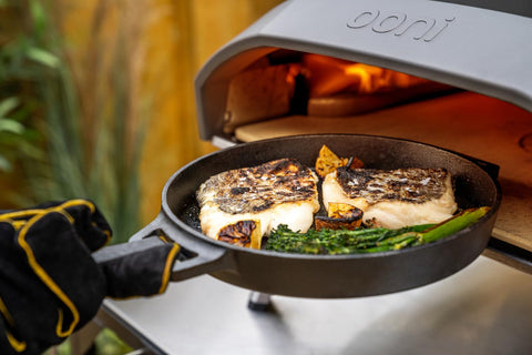 Ooni skillet searing meat and seafood with rich flavor.