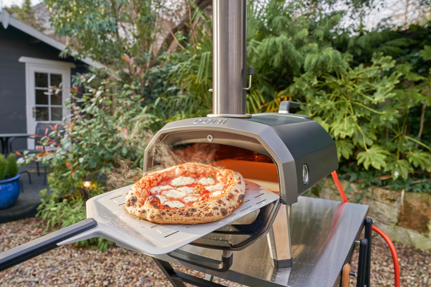 Ooni perforated pizza peel with long handle keeps hands safe.