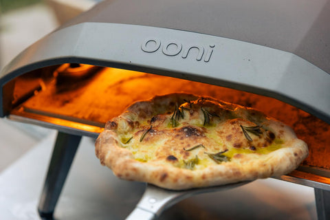 Ooni pizza turning peel enables quick rotation near the stone for even cooking.