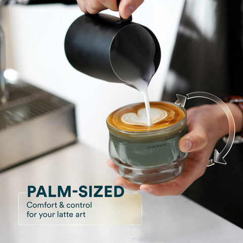 Ovalware latte art cups in use on a counter, swirling creamy designs.