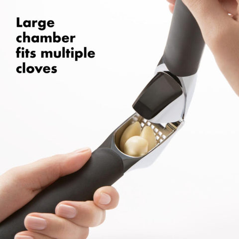 OXO Good Grips garlic press built-in cleaner demonstrating easy peel removal feature