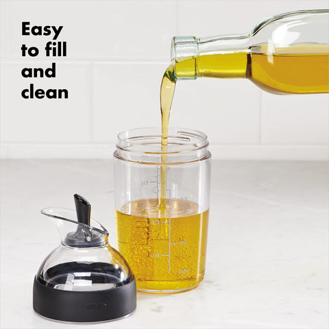OXO Good Grips mini dressing shaker pour lever in hand for controlled serving