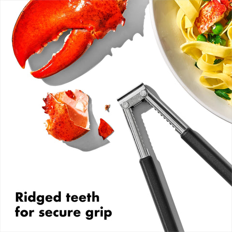OXO Good Grips seafood & nut cracker in use cracking a crab leg.