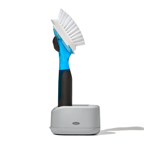 OXO Good Grips soap-dispensing dish brush releases soap with a gentle press for quick washing