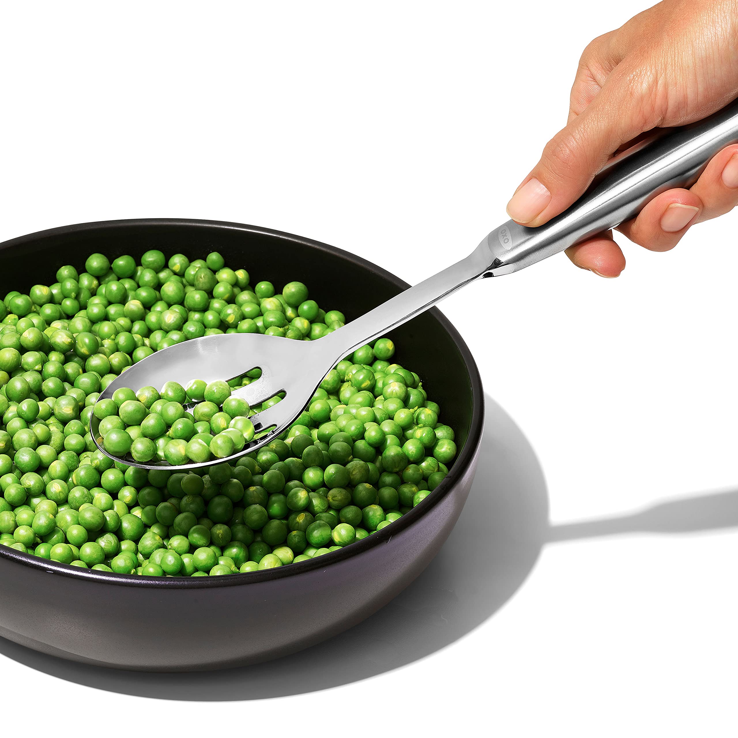 OXO Steel Slotted Serving Spoon close-up showing evenly spaced drainage slots