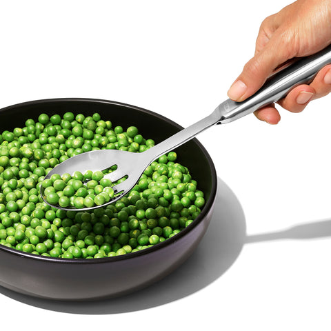 OXO Steel Slotted Serving Spoon close-up showing evenly spaced drainage slots
