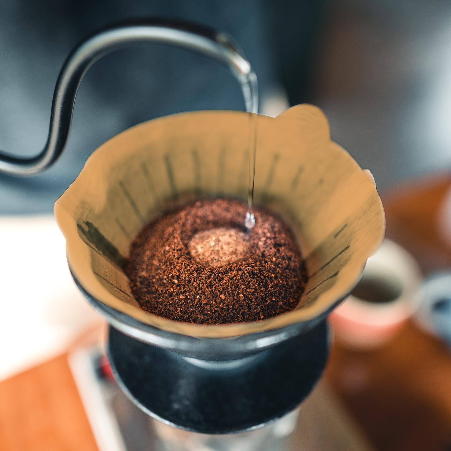 PakTalk cone filter 4 natural brown paper being held over a cup