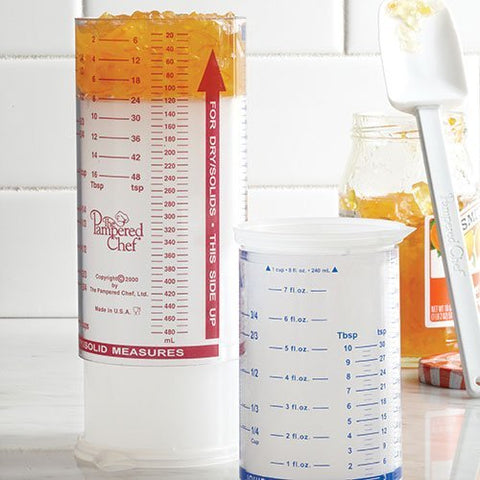 Pampered Chef Measure All Cup with adjustable plunger for precise solids and liquids.