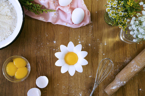 Peleg Design Daisy separator in use over cup to crack eggs cleanly
