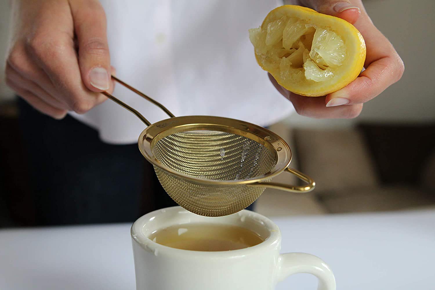 Proto Future strainer with sturdy gold handle for easy pouring and draining
