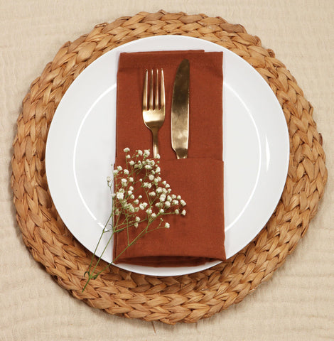 PurpleEssences rust napkins folded on table show neat mitered corners.