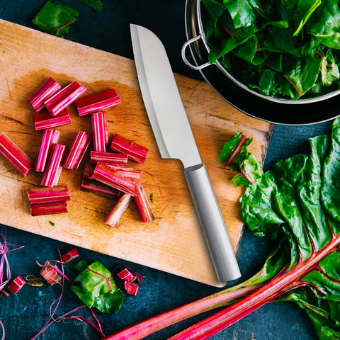 Herbs and vegetables being chopped with even, precise dices