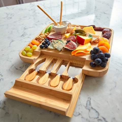 RoyalHouse charcuterie setup with cheese, fruit, and crackers on bamboo board