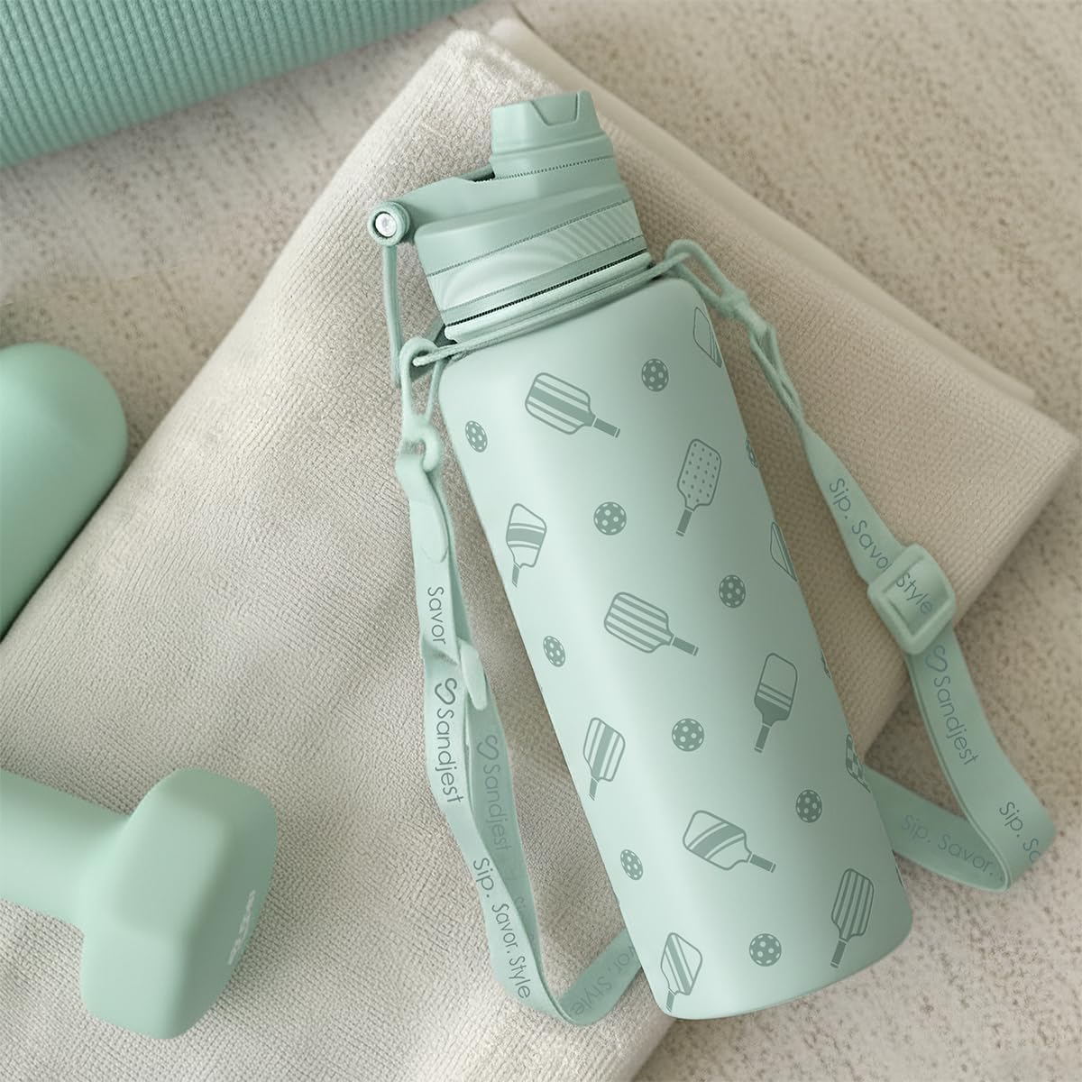 SANDJEST bottle on outdoor trail highlights easy portability and spill-free sipping.