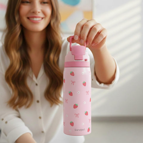 Sandjest Strawberry Bow bottle pictured with workout gear for fitness and travel.