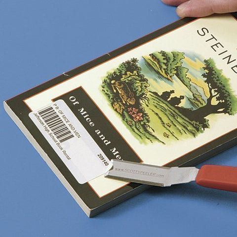 Scotty Peeler SP-2 in action on glass, removing a sticker with precision.