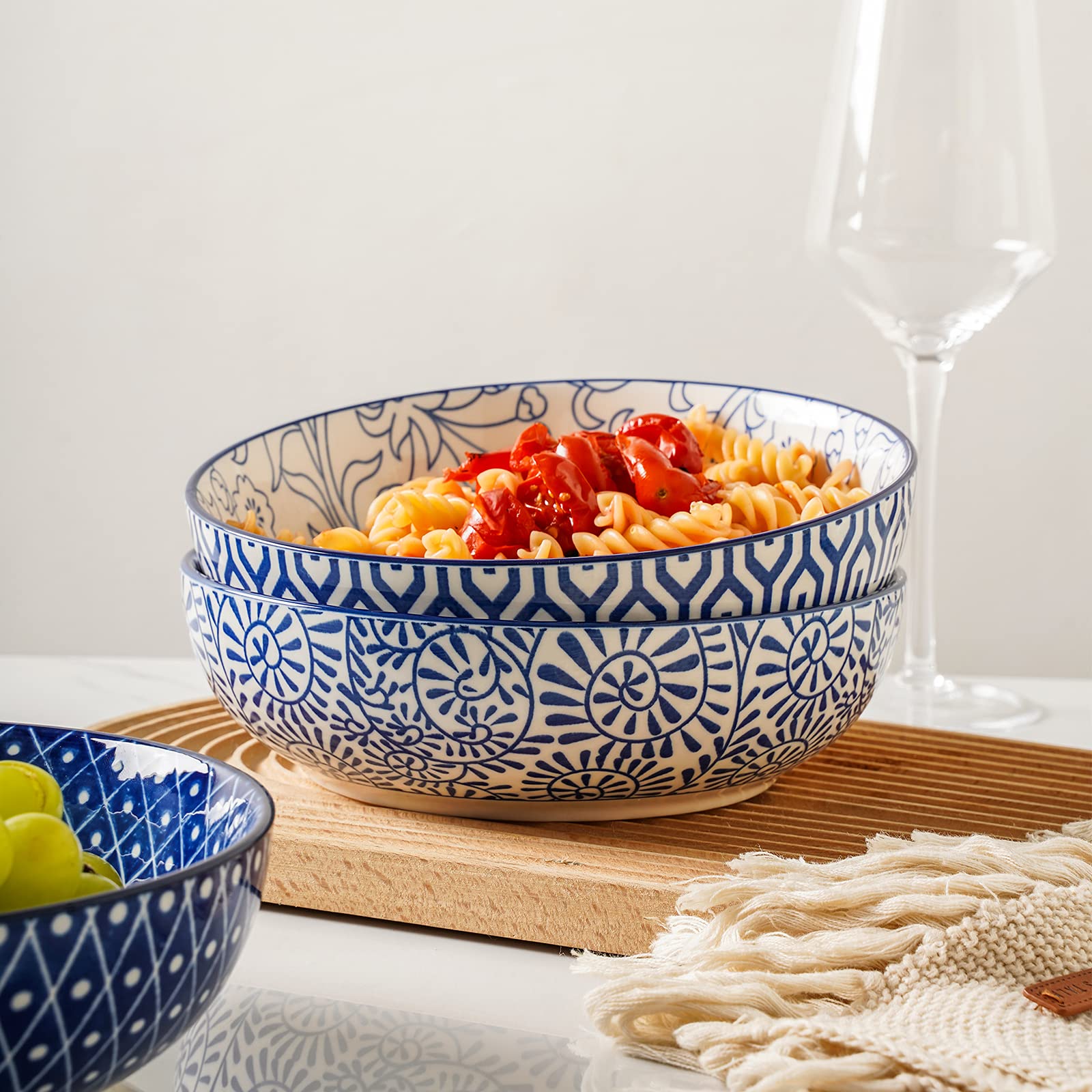 Selamica pasta bowls in-use with spaghetti, showing wide shallow design for easy serving.