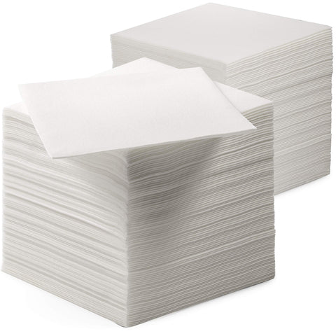 Servietto linen-feel beverage napkins folded on a formal table for clean spills.