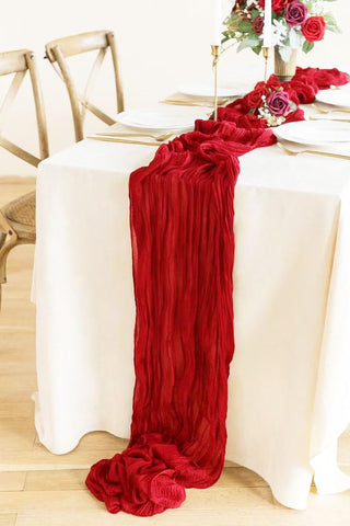 Seveups red table runner complements candles and linens for versatile event decor.