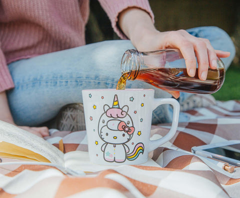 Silver Buffalo Hello Kitty Unicorn mug stacked with other Sanrio collectibles.