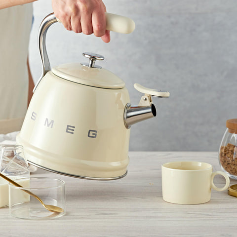 Smeg kettle cream side view, ergonomic handle and confident presence.
