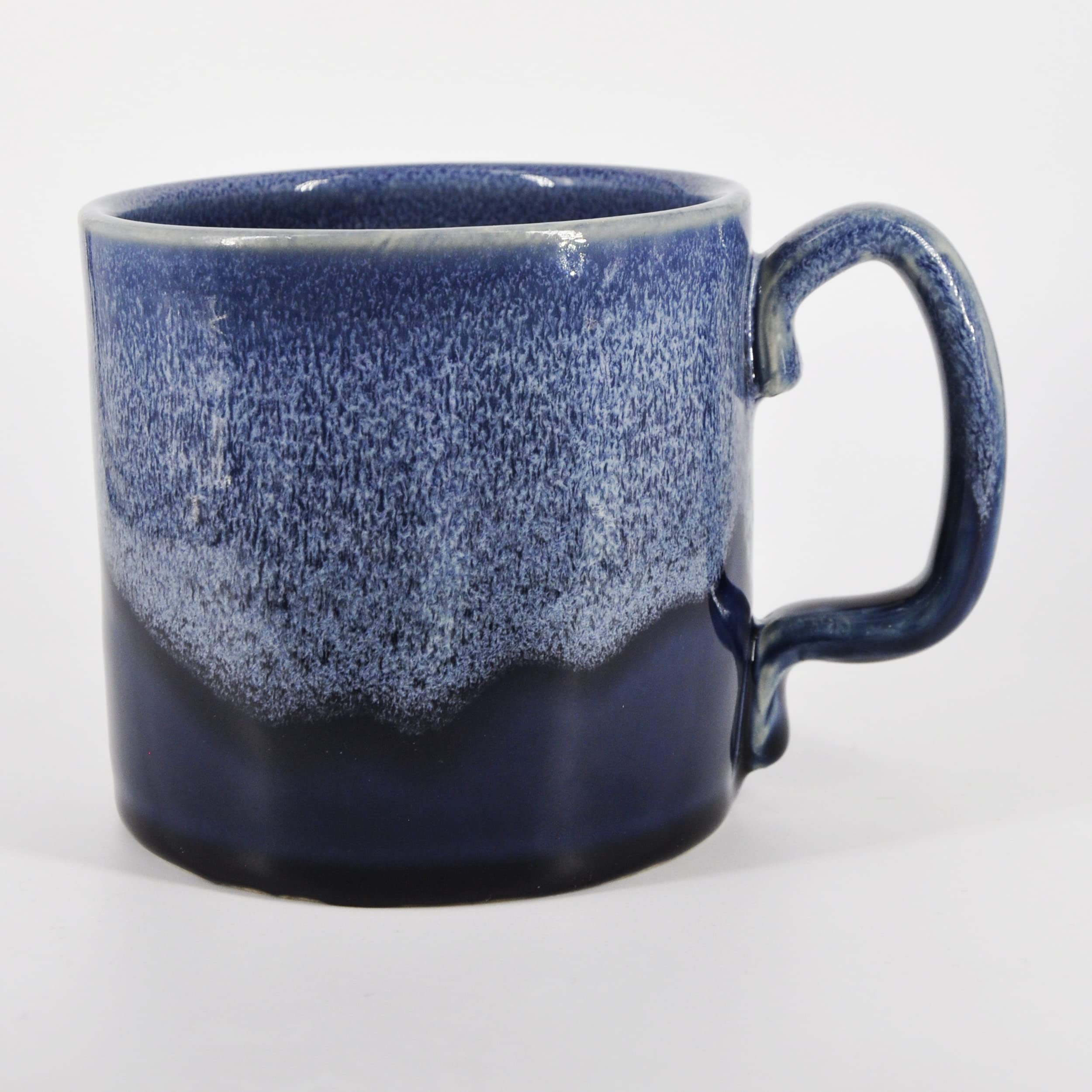 SnowSwept Studio Ol' Blue mug held in hand highlights comfortable grip and handcrafted charm.