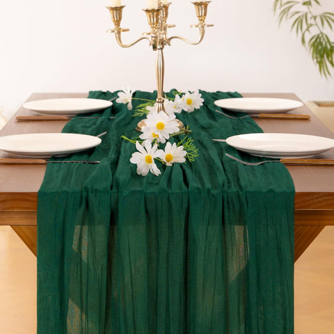 Socomi emerald-green cheesecloth runner pairs with greenery and candles for ambiance