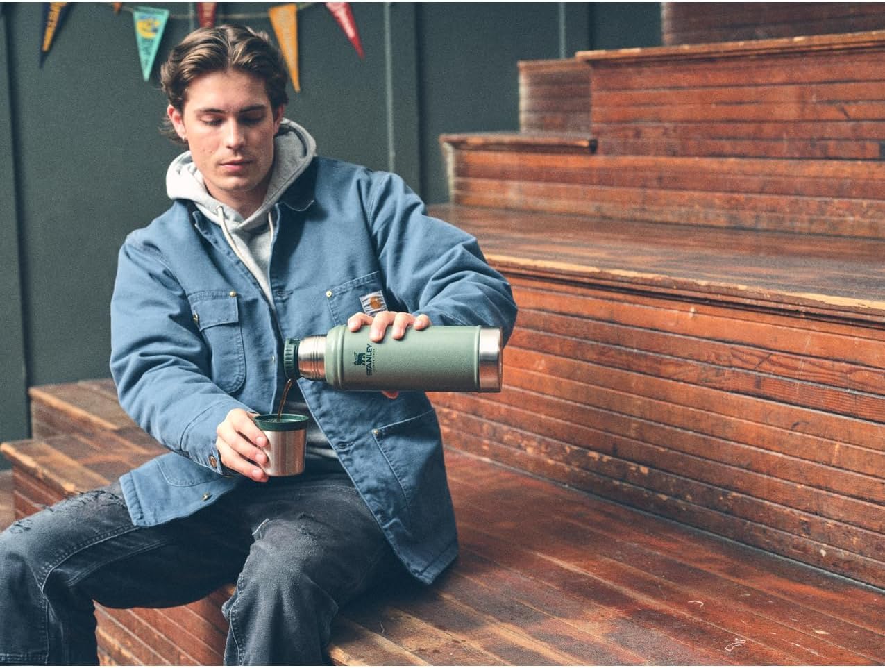 Stanley Classic 20 oz bottle with cup lid in action for quick sipping.