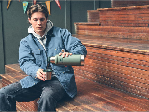 Stanley Classic 20 oz bottle with cup lid in action for quick sipping.