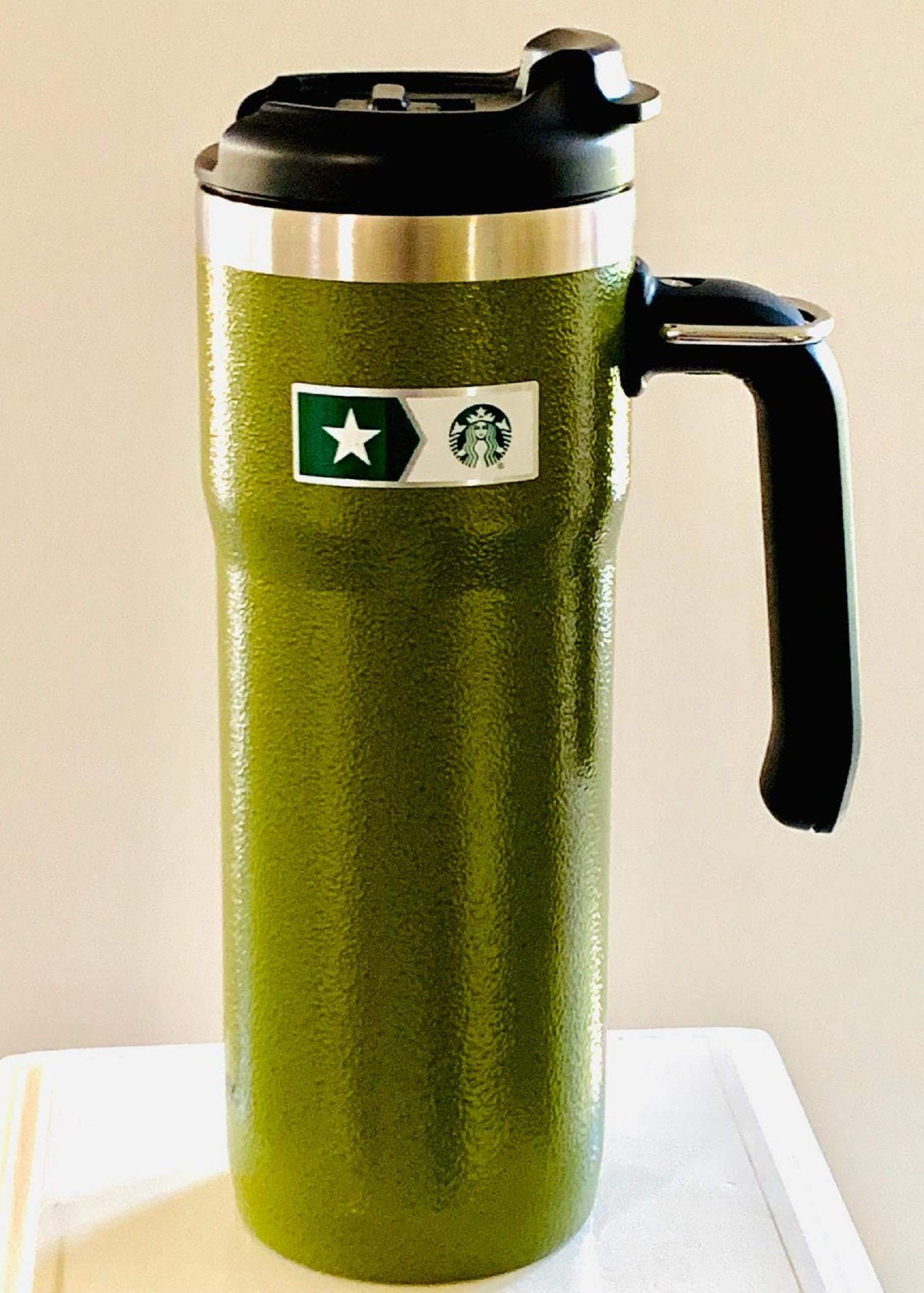 Starbucks Stanley hammered finish tumbler with handle keeps drinks portable.