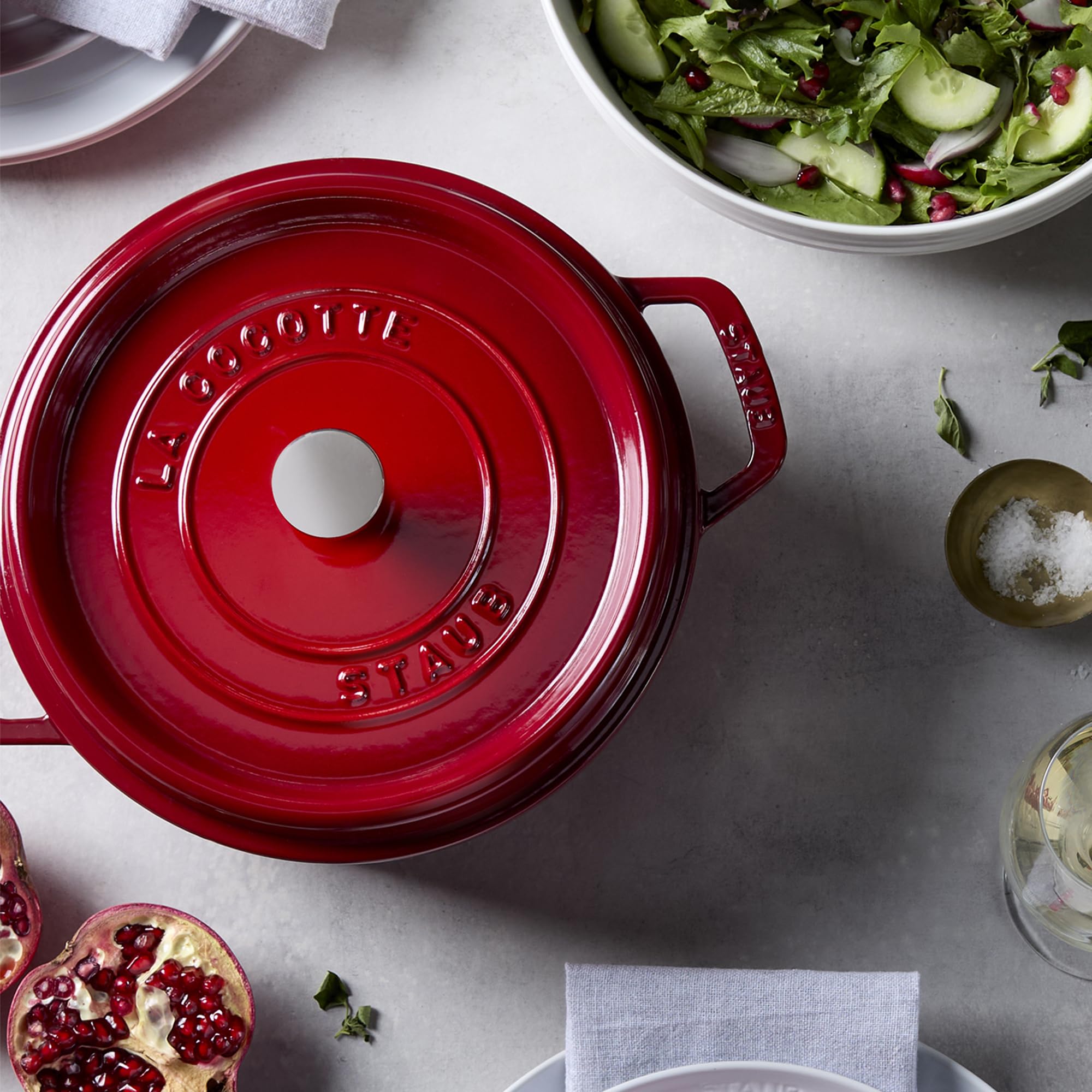 STAUB cocotte on stovetop shows compatibility with gas and induction for even heating.