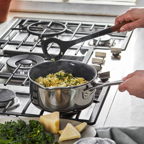 STAUB risotto spoon with acacia wood handle for comfortable grip.