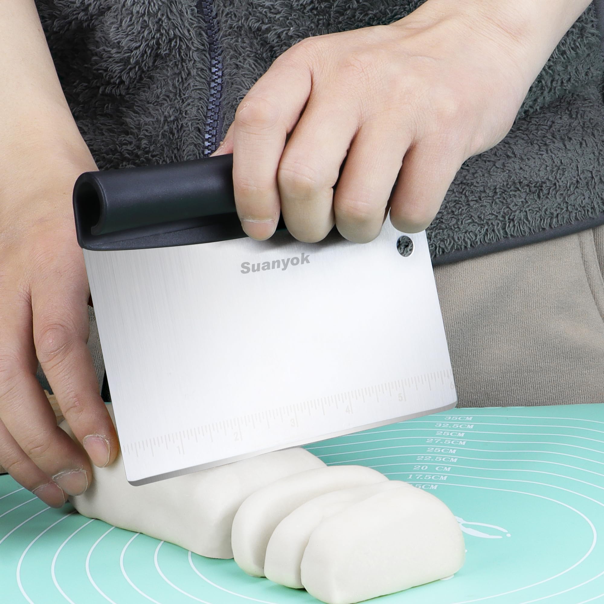 Suanyok flexible plastic dough scraper with handle shapes dough on a mat