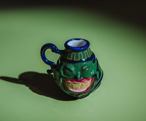 Surreal Entertainment Pot Of Greed mini mug blue flourishes provide vibrant accents.