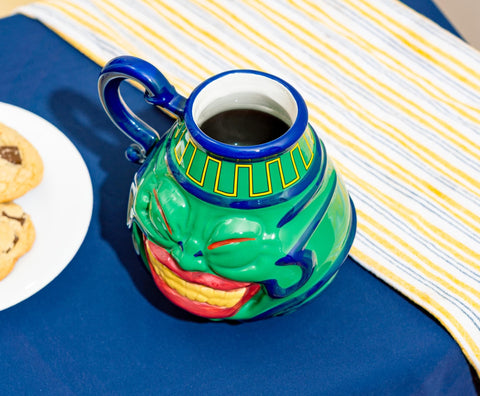 Surreal Entertainment Pot of Greed mug, on a desk as a playful accent.