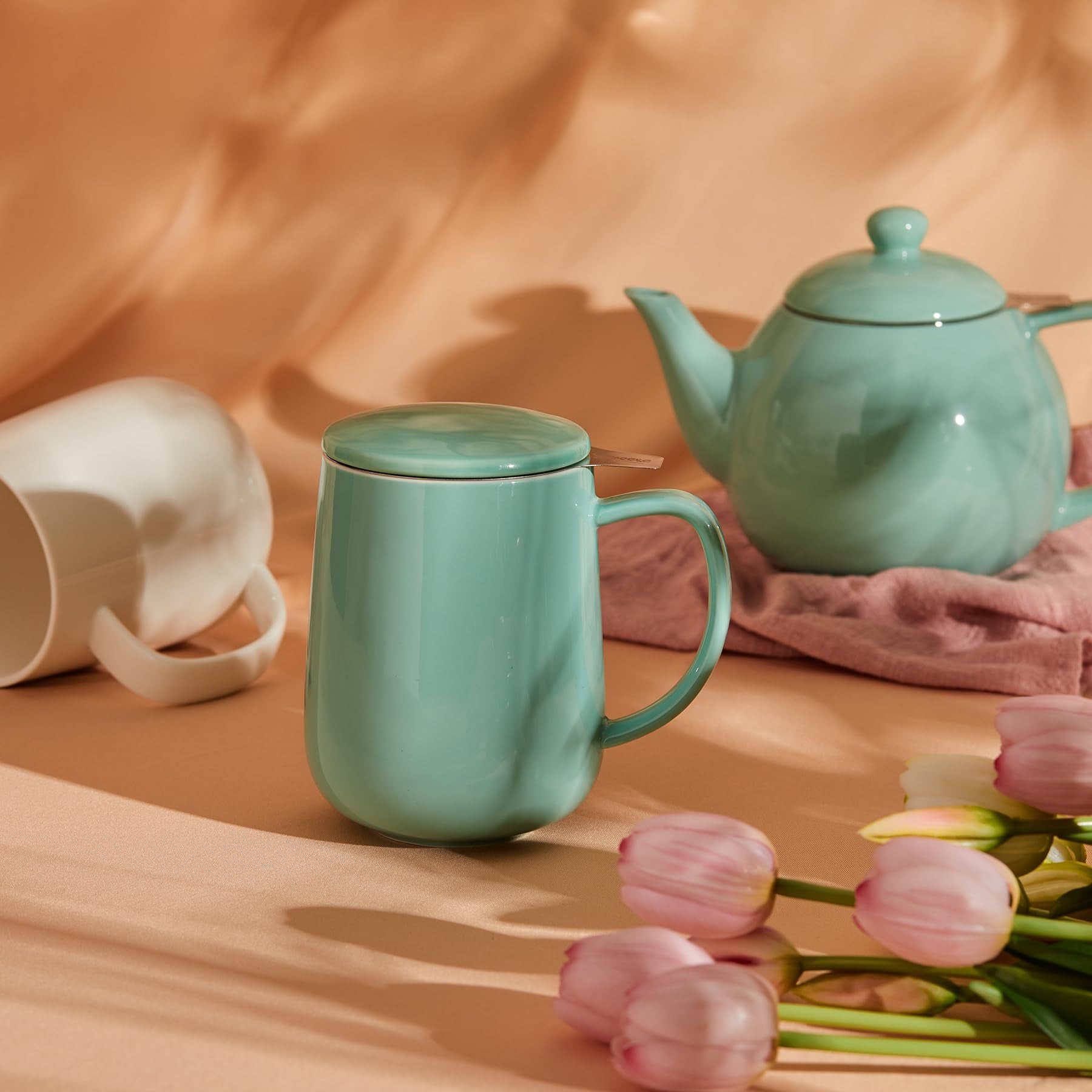 Sweese tea mug with lid in mint-green, side view.