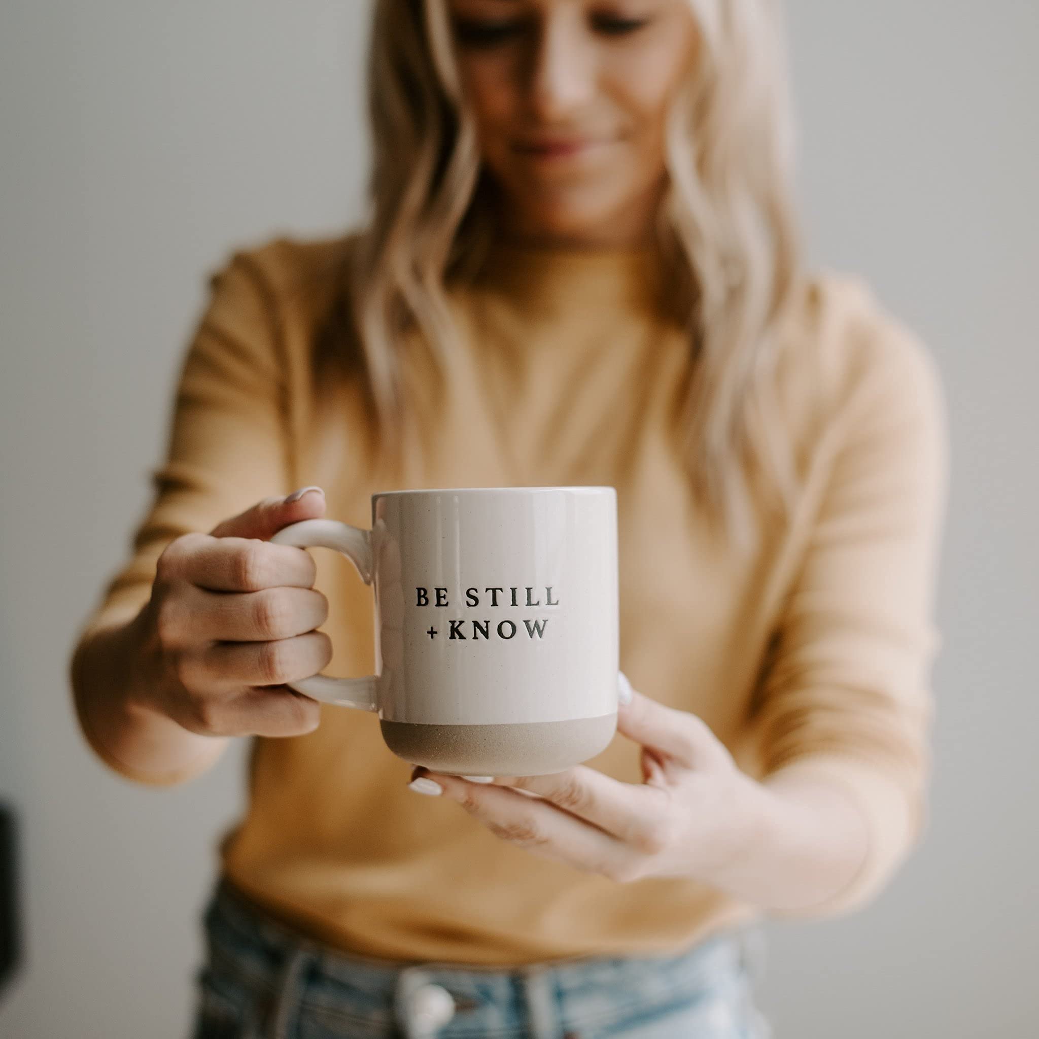 Sweet Water Decor Be Still and Know mug in use with coffee for morning routine.