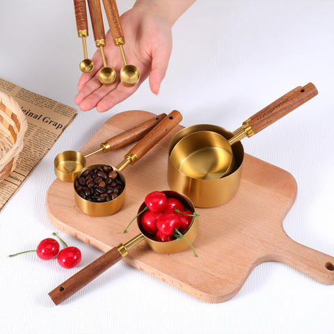 SynHHnergyx measuring spoons in gold finish with comfortable wooden handles.
