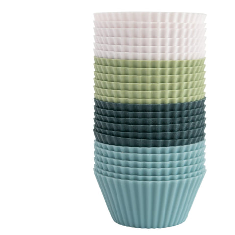 The Silicone Kitchen baking cups in navy, dusty blue, sage green, and white prevent sticking