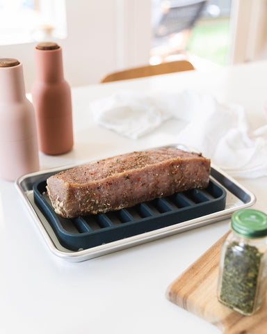 The Silicone Kitchen navy rack fits 9x13 dishes for versatile roasting.