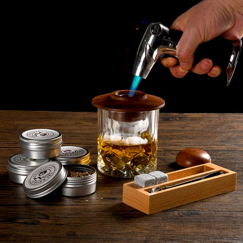 The Whiskey Underground hand torch in use for precise cocktail smoking.