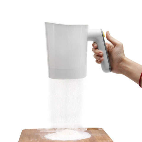 Tookie electric flour sifter in white cup angled view for light, lump-free flour.