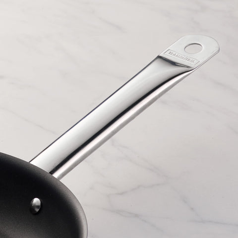 Tramontina 8-inch pan handle closeup shows sturdy riveted grip for confident lifting.