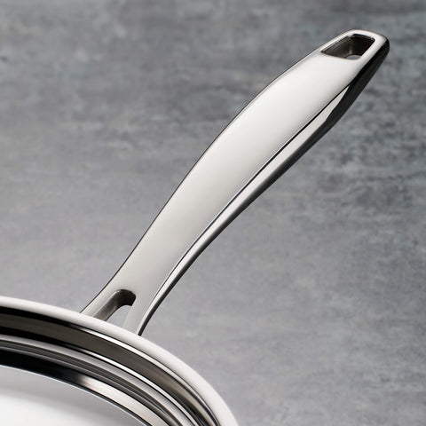 Tramontina tri-ply clad pan lid close-up emphasizes durable stainless steel construction.