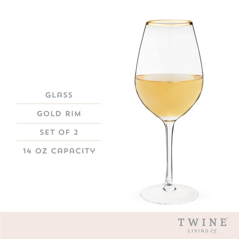 Twine 14 oz wine glass with gold rim on a candlelit table.