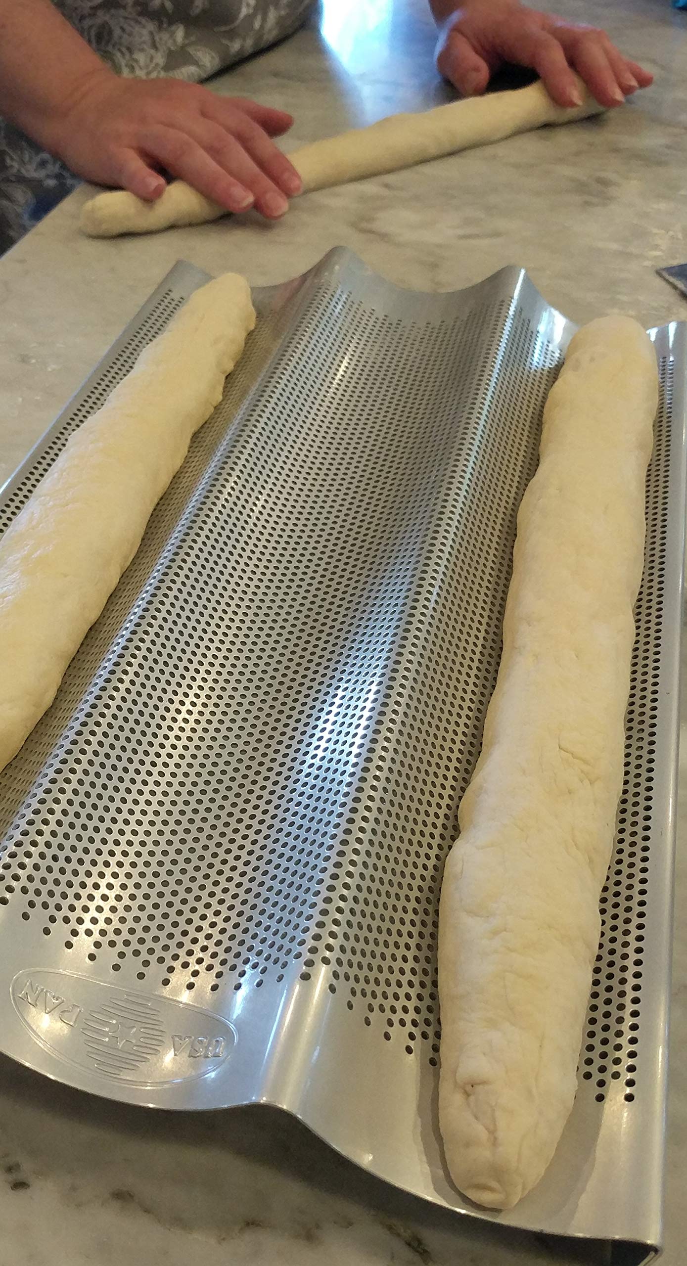 USA Pan baguette pan perforated bottom heat circulation supports crusty exterior and soft interior.