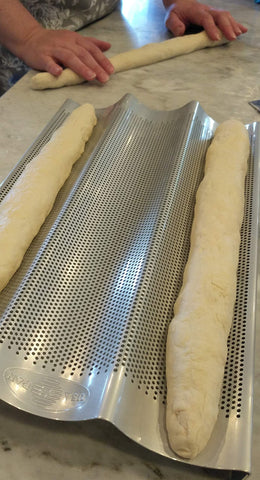 USA Pan baguette pan perforated bottom heat circulation supports crusty exterior and soft interior.