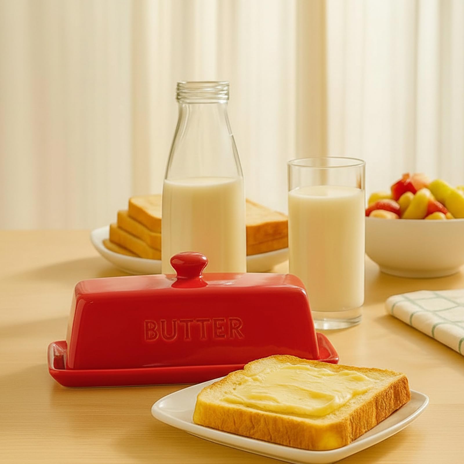 Stainless steel 3-in-1 spreader beside the red butter dish.