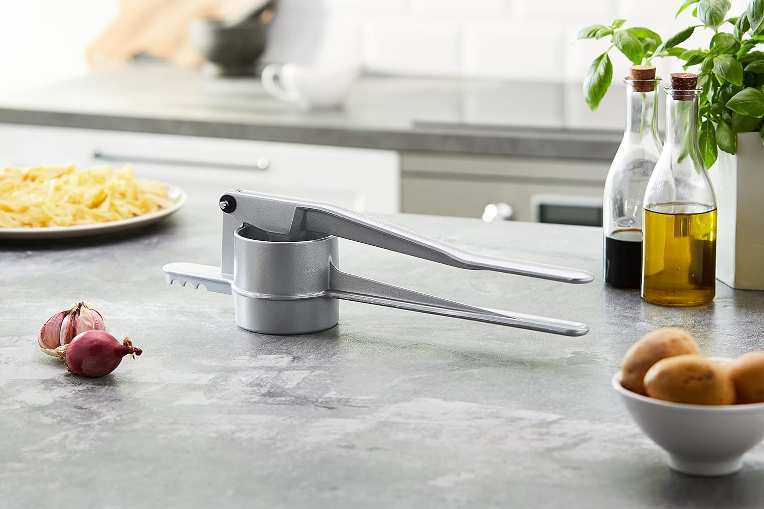 Westmark Spaetzle Classic with hinged handle for controlled dough pressing.