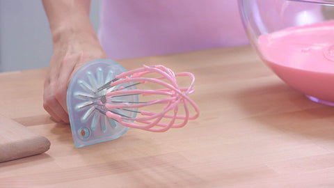 Whisk Wiper's drip-catch feature during sauce preparation